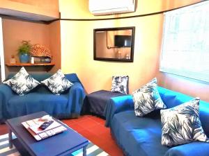 a living room with blue couches and a mirror at Cango Retreat Breathe in Oudtshoorn