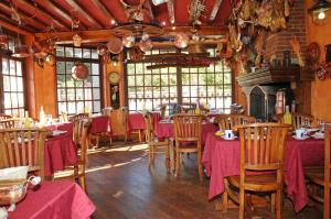 jadalnia ze stołami i krzesłami w restauracji w obiekcie L'Escale w Étretat
