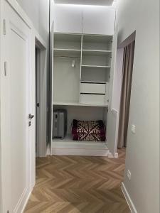 a hallway with a room with white shelves and a floor at Brand new one bedroom apartment with amazing view in Bishkek