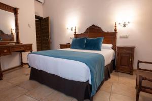 a bedroom with a large bed with blue pillows at María de Molina in Úbeda
