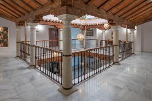 an indoor hallway with columns and a ceiling with chandeliers at Hotel María de Molina in Úbeda