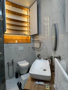 a bathroom with a sink and a toilet and a mirror at Brand new one bedroom apartment with amazing view in Bishkek