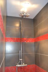 łazienka z prysznicem wyłożona czerwonymi kafelkami w obiekcie Chambres d'hôtes l'Armancière w mieście Saint-Marcellin