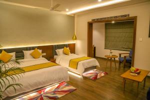 a hotel room with two beds and a table at Four Leaf Hotel - Sapphire Blue, Varanasi in Varanasi +52 photos