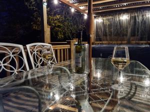 dois copos de vinho branco sentados numa mesa em Riverside Cabin in Shropshire em Oswestry