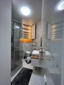 a bathroom with a shower and a sink and a toilet at Brand new one bedroom apartment with amazing view in Bishkek