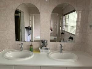 ロードポートにあるSafari Deluxe Rooms - elegant rooms with access to beautiful garden & poolの洗面台が2つと鏡があるバスルーム +66枚の写真