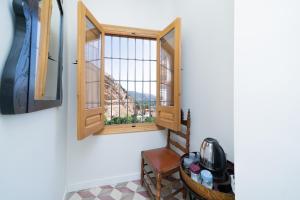 a room with a window and a chair with a view at Villa Moana in Iznájar