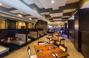 a restaurant with tables and chairs and a bar at Crowne Plaza Shenandoah - The Woodlands Area by IHG in The Woodlands