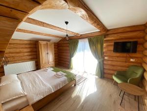 a bedroom with a bed and a tv and a window at Cabana 9 in Borşa