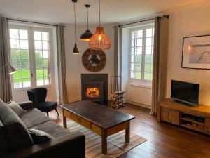 a living room with a couch and a fireplace at Domaine de Cazal - Gîte 4 pers au coeur d'un Domaine Privé avec Piscine, Nature & Calme près de Sarlat in Saint-Cyprien