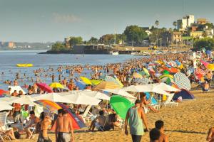 una gran multitud de personas en una playa con sombrillas en Atalaya en Colón