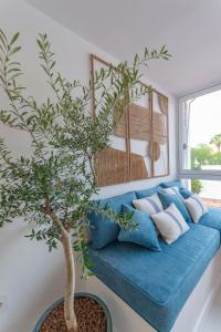 a blue couch with a tree in a room at Apartamento nuevo y moderno in San Bartolomé