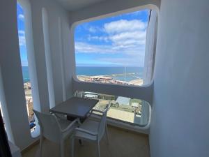 a table and chairs in a room with a view of the ocean at Hotel Azur in Casablanca