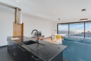 a kitchen with a sink and a living room at Casa Mozart II in Estreito da Calheta