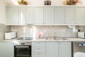 a kitchen with white cabinets and a sink at Kokkinos Studios With Pool & Sea View, by ZanteWize in Skinária