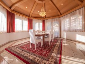 une salle à manger avec une table et des chaises sur un tapis dans l'établissement Villa Octogon, à Loèche-les-Bains