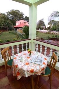 uma mesa e cadeiras numa varanda com uma mesa e uma janela em Alps Residency em Madurai