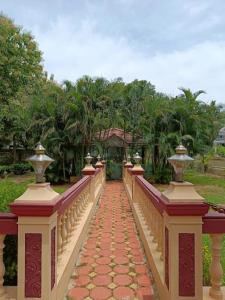 a bridge with a walkway leading to a house at Alps Residency in Madurai