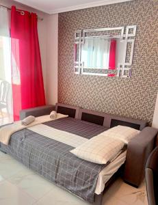 una camera da letto con un letto con specchio e tende rosse di Elegant style 3-bedroom brand new apartment a San Miguel de Abona