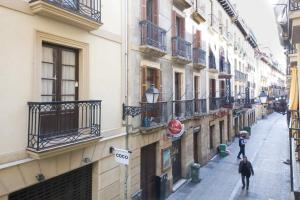 a couple of people walking down a street next to buildings at Cómodo apartamento en la Parte Vieja, Old Town in San Sebastián