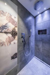 y baño con ducha y una pintura en la pared. en Ferienwohnungen Fichtenheim, en Mayrhofen