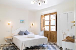 a white bedroom with a bed and a checkered floor at Villa Moana in Iznájar