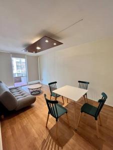 Una sala de estar con una mesa y sillas y un sofá. en Central y cómodo Depto en Providencia, en Santiago