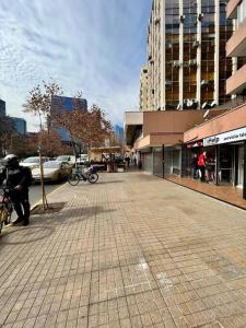 una calle vacía en una ciudad con edificios altos en Central y cómodo Depto en Providencia, en Santiago
