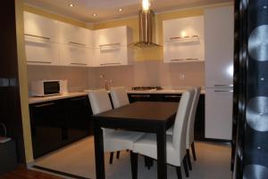 a kitchen with a black table and white chairs at Living Room in Tarnów