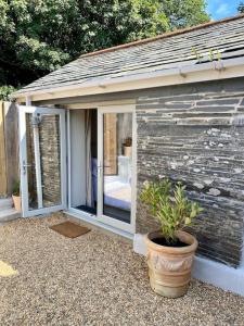 a small house with a potted plant in front of it at Mowhay Barn in Bodmin
