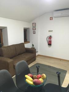 a living room with a bowl of fruit on a glass table at Casa do Castelo II in Bragança