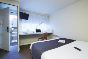 
A bed or beds in a room at Campanile Lille Sud - CHR
