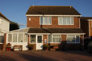 a red brick house with a white garage at Leeward House B&B in Gosport