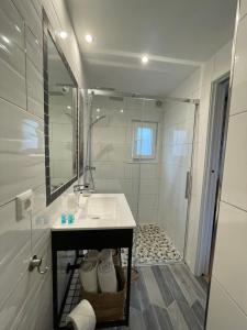 La salle de bains blanche est pourvue d'un lavabo et d'une douche. dans l'établissement B&B Casa El Viaje, à Cómpeta