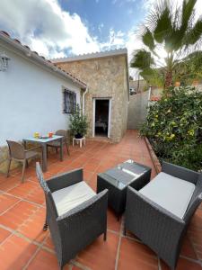 patio z wiklinowymi meblami, stołem i krzesłami w obiekcie B&B Casa El Viaje w mieście Cómpeta