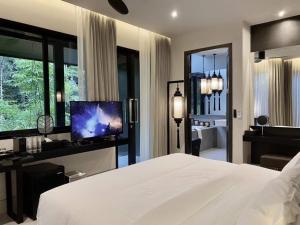 um quarto com uma grande cama branca e uma televisão em S.House168 em Chiang Mai
