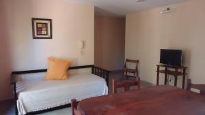 Cette chambre comprend un lit, une table et une télévision. dans l'établissement Atalaya, à Colón