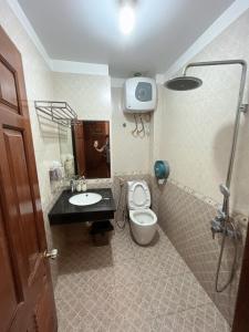 a bathroom with a toilet and a sink and a shower at Khách Sạn Nam Sơn in Ðông Khê