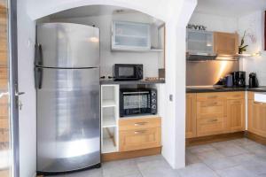 a kitchen with a stainless steel refrigerator and a microwave at Charmante Amiénoise 2 chambres in Amiens