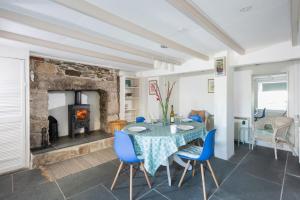 a dining room with a table and a fireplace at Rosevean in Marazion