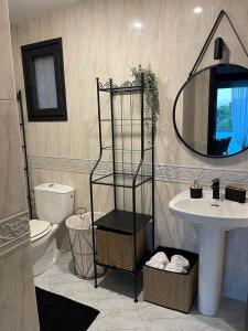 a bathroom with a sink and a toilet and a mirror at Villa Bella in Castelldefels