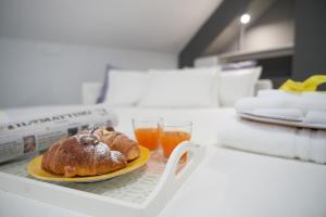 un plato con un pastel y un vaso de zumo de naranja en B&B Milleduecento Luxury Room, en Salerno