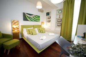 a bedroom with a bed and a green chair at B&B Milleduecento Luxury Room in Salerno