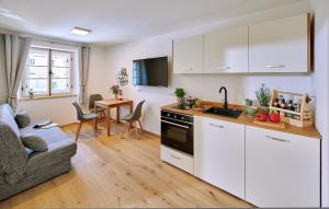 a kitchen with white cabinets and a living room at Ferienwohnung Tittmoning Stadtplatz in Tittmoning