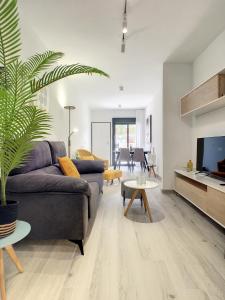 a living room with a couch and a tv at Elisa Beach Apartment - 8209 in Santiago de la Ribera