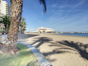 een palmboom op het strand naast het water bij Elisa Beach Apartment - 8209 in Santiago de la Ribera