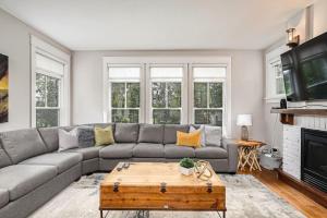 a living room with a gray couch and a coffee table at Luxurious Rivergrass Blue Mountain Retreat in Blue Mountains