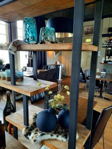ein Zimmer mit einem Tisch mit Vasen auf einem Regal in der Unterkunft De Gouden Molen in Rossum