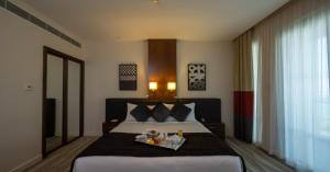 a bedroom with a bed with a tray of food on it at Staybridge Suites Yas Island Abu Dhabi, an IHG Hotel in Abu Dhabi
